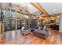 Spacious living room featuring a soaring ceiling, large windows, hardwood floors, and a comfortable sectional sofa at 14582 Homestead Pl, Broomfield, CO 80023