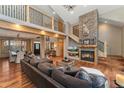 Open-concept living room features a stone fireplace, hardwood floors, and access to the staircase at 14582 Homestead Pl, Broomfield, CO 80023