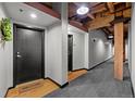 Hallway with exposed wood beams, hardwood, gray carpet, and a 'Welcome' mat at the front door at 1745 Wazee St # 3C, Denver, CO 80202