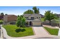 Charming two-story home with a manicured lawn, mature trees, and a spacious driveway leading to a two-car garage at 201 Shenandoah Way, Brighton, CO 80603