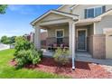 Cozy front porch with lovely seating, charming brick accents and immaculate landscaping at 201 Shenandoah Way, Brighton, CO 80603