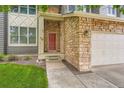Inviting front entry featuring stone accents and a stylish red door for a warm welcome at 5136 S Ceylon St, Centennial, CO 80015