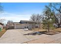Well-manicured front yard leads to this charming split-level home with a two-car garage at 8092 S Jay Dr, Littleton, CO 80128