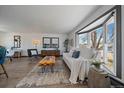 Bright living room featuring a bay window, white sofa, and stylish decor elements at 8092 S Jay Dr, Littleton, CO 80128