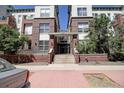 Condominium exterior featuring gated entrance, staircase, and beautiful brickwork at 1727 Pearl St # 205, Denver, CO 80203