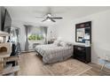 Bright bedroom featuring a ceiling fan, large window, and a comfortable bed at 9150 E Center Ave # 7C, Denver, CO 80247