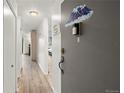Inviting foyer hallway with light wood floors and neutral wall colors at 9150 E Center Ave # 7C, Denver, CO 80247