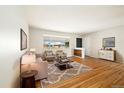 Bright living room featuring hardwood floors, a large window, and neutral decor at 396 S Troy St, Aurora, CO 80012