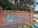 Brick sign with 'Deer Pointe Brittany Highlands' in teal lettering, surrounded by greenery at 1870 S Pitkin Cir # B, Aurora, CO 80017