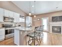 Eat-in kitchen featuring stainless steel appliances, granite countertops, and a cozy fireplace at 479 W Jamison Cir, Littleton, CO 80120