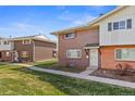 Exterior view of a two story brick home with a well maintained lawn and landscaping at 9044 E Nassau Ave, Denver, CO 80237
