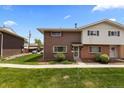 A brick home with a well-manicured lawn offers curb appeal and a welcoming exterior on a sunny day at 9044 E Nassau Ave, Denver, CO 80237