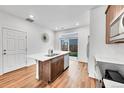 Bright kitchen with stainless steel appliances, center island, white countertops, wood cabinets, and sliding glass door to the yard at 210 S Old Hammer Ct, Aurora, CO 80018