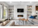Cozy living room featuring a modern fireplace, floating shelves, and stylish furniture at 9154 E 37Th Ave, Denver, CO 80238