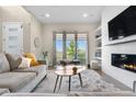 Bright living room with large windows, modern fireplace, and a comfortable seating area at 9154 E 37Th Ave, Denver, CO 80238