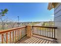 Balcony with wooden railing offering neighborhood views on a sunny day at 7511 S Sicily Way, Aurora, CO 80016