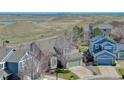 A cozy two-story home with a well-maintained lawn and landscaping, complemented by a scenic view of distant hills at 4142 S Deframe Ct, Morrison, CO 80465