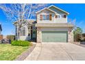 Charming two-story home featuring stone accents, a two-car garage, and a well-manicured lawn with beautiful landscaping at 4142 S Deframe Ct, Morrison, CO 80465