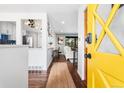 Inviting entryway with a bright yellow door, hardwood floors, and an open view into the living spaces at 6445 Balsam St, Arvada, CO 80004