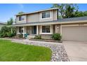 Beautiful home exterior showing a manicured lawn and charming walkway lined with river rock at 8433 S Painted Sky St, Highlands Ranch, CO 80126