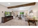 Bright living room features a decorative beam, modern flooring, and large window overlooking the yard at 8433 S Painted Sky St, Highlands Ranch, CO 80126