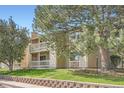 Apartment building featuring two stories with balconies and attractive landscaping at 8225 Fairmount Dr # 104, Denver, CO 80247