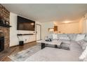 Open-concept living room with a modern sectional, a fireplace, and an open view to the kitchen at 8225 Fairmount Dr # 104, Denver, CO 80247