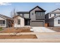 Inviting two-story gray home featuring a two-car garage, a modern design, and great curb appeal at 9973 Worchester St, Commerce City, CO 80022