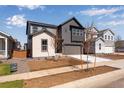 Attractive two-story gray home featuring a two-car garage, and a beautifully landscaped front yard at 9973 Worchester St, Commerce City, CO 80022