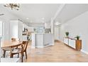 Bright, open-concept living space featuring hardwood floors and a kitchen with modern white cabinetry at 6324 Winona St, Arvada, CO 80003