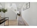 Bright foyer showcases light wood floors, white walls, and a modern staircase at 6099 N Netherland Ct, Aurora, CO 80019
