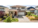 Landscaped two-story home boasts a welcoming entrance and attached two car garage at 6099 N Netherland Ct, Aurora, CO 80019