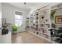 Home office space with built-in white bookshelves, a large window, and wood floors at 6099 N Netherland Ct, Aurora, CO 80019