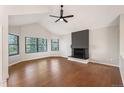 Spacious living area with hardwood floors, large windows, and a painted brick fireplace at 18 Brixham Ct, Castle Pines, CO 80108
