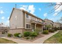 Inviting townhouse exterior with a brick foundation, manicured landscaping, and a cozy front entryway at 1470 S Quebec Way # 178, Denver, CO 80231