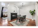 Elegant dining room with fireplace, chandelier, hardwood floors, and backyard views at 12826 W Brittany Dr, Littleton, CO 80127