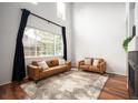 Bright living room with soaring ceilings, expansive windows, and cozy seating arrangement at 12826 W Brittany Dr, Littleton, CO 80127