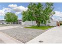 View of the home's front yard, ample parking, and welcoming facade at 687 Prairie Ave, Brighton, CO 80603