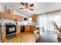 Bright kitchen boasts wood floors, stainless steel range, and plenty of natural light from windows at 687 Prairie Ave, Brighton, CO 80603