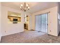 Carpeted dining area with sliding door access to the exterior and views of the kitchen at 13940 E Linvale Pl, Aurora, CO 80014