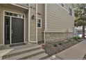 A welcoming front entrance with stone accents and a gray front door at 1356 Carlyle Park Cir, Highlands Ranch, CO 80129