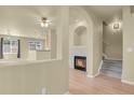 A bright, open-concept living room featuring a fireplace and archways at 1356 Carlyle Park Cir, Highlands Ranch, CO 80129