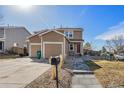 Inviting two-story home with a well-maintained yard, and attached two-car garage under a beautiful clear sky at 715 Mockingbird St, Brighton, CO 80601