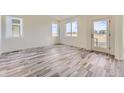 Bright, open living room with hardwood floors and natural light from large windows and a glass door at 1288 S Algonquian St, Aurora, CO 80018