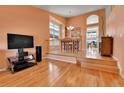 Open-concept living room with hardwood floors and natural light from large windows at 20948 E Hamilton Ave, Aurora, CO 80013
