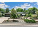 Charming home with lush front yard landscaping, a lovely walkway, and beautiful trees at 3519 S Holly St, Denver, CO 80237