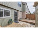 Exterior of the home with a wood deck and black decorative security door, next to a small garden at 3415 S Ammons St # 24-2, Lakewood, CO 80227