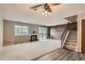 Living room with a fireplace, wood accent wall, carpet flooring, and staircase at 3415 S Ammons St # 24-2, Lakewood, CO 80227