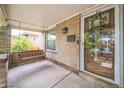 Inviting covered front porch with swing, brick accents, and mailbox near the glass front door at 3024 W Denver Pl, Denver, CO 80211