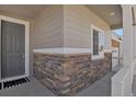 Inviting front porch with stone accents and a stylish gray front door at 5166 Trails Edge Ln, Castle Rock, CO 80104